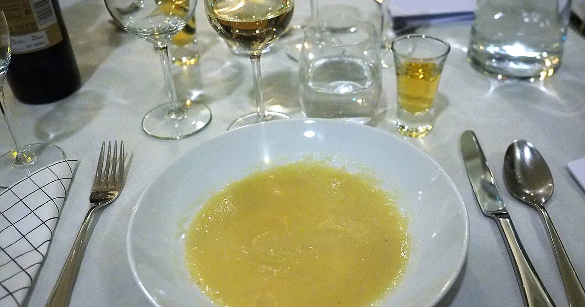 A bowl of Jerusalem artichoke soup with a glass of white wine, a glass of water and a small glass of akvavit served as a starter at an academic sittning in Helsinki, Finland.