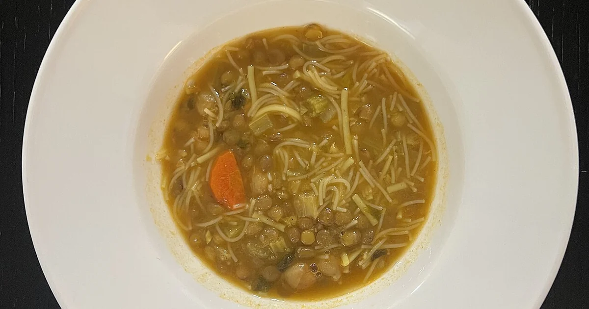 High-quality photograph by Liat Portal showing a bowl of traditional Moroccan harira soup with lentils, chickpeas, vermicelli noodles, vegetables, and spices, photographed from above. This image documents harira soup as part of the Foodie D