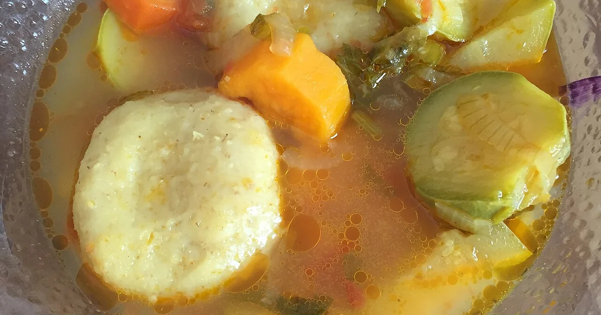 High-quality photograph by Liat Portal showing a bowl of Iraqi Jewish kubbeh soup, with kubbeh cooked in a vegetable soup containing celery, carrots, and green zucchini. The kubbeh were store-bought frozen and cooked by Liat Portal in a hom