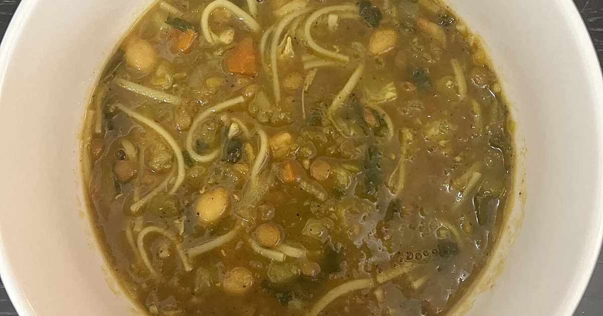 High-quality photograph by Liat Portal showing a bowl of homemade harira soup with visible chickpeas, lentils, vegetables, herbs, and noodles in broth. This image documents everyday home cooking, cultural food continuity, food literacy, and