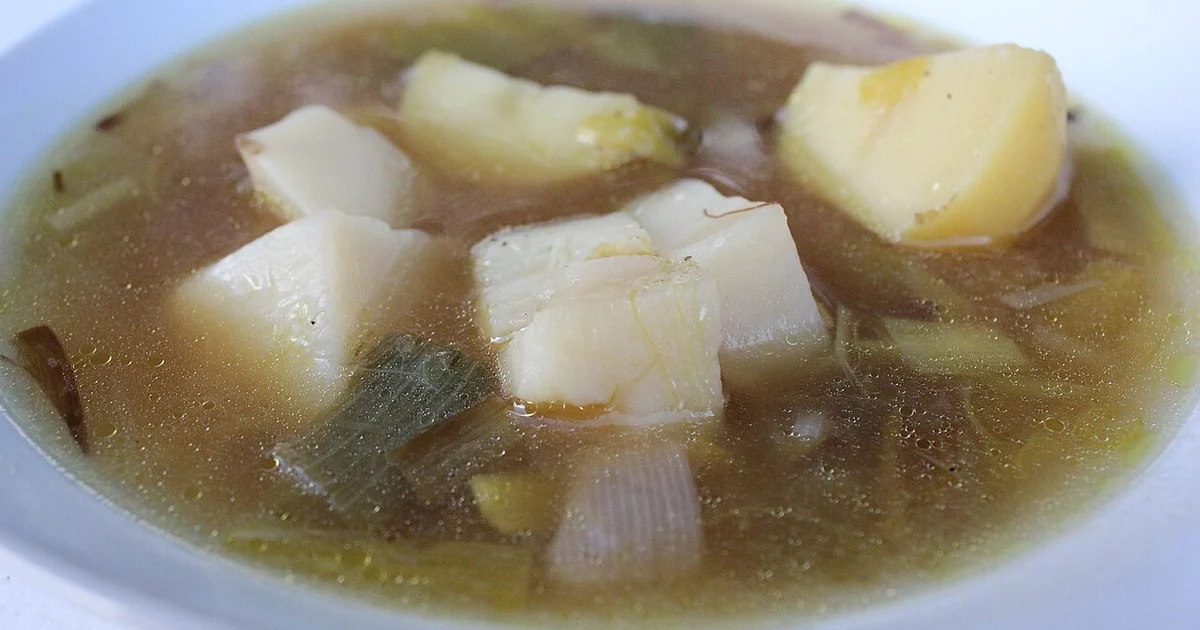 Leek soup consisting of leeks, russet potatoes, and chicken broth in a white bowl. Vegetarian if vegetable broth is used as a substitute.